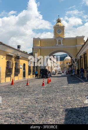 La célèbre arche jaune de Santa Catalina encadrant le lointain dôme blanc de l'église la Merced sur une rue pavée à Antigua Guatemala. Banque D'Images