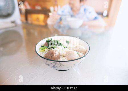 Un bol fumant de soupe aux boulettes de bœuf taïwanaise avec des légumes frais, servi sur une table brillante avec Banque D'Images