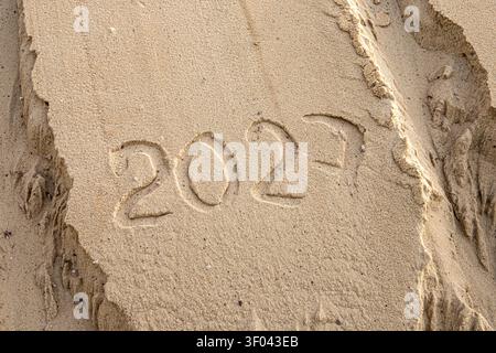 2027 écrit dans du sable sec sur fond naturel de nouvel an de surface sableuse Banque D'Images