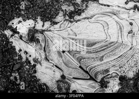 Arrière-plan : ressource graphique d'art naturel. Glace sur une flaque gelée en noir et blanc à bas niveau de lumière. Banque D'Images