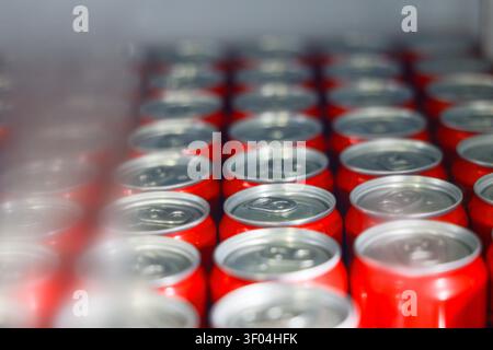 Un soda rouge peut se refermer avec un dessus argenté en rangées, créant un motif vibrant et répétitif avec une faible profondeur de champ et une mise au point douce au premier plan et Banque D'Images