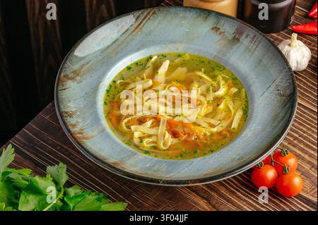 Bol rustique de soupe de nouilles au poulet maison sur une table Banque D'Images