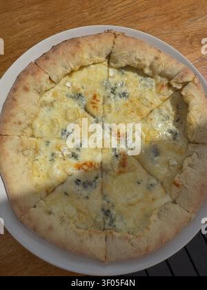 Pizza aux quatre fromages fraîchement cuite sur une table en bois, vue de dessus, fromage fondu, croûte croustillante, cuisine italienne, plat réconfortant fait maison, repas de restaurant et espace pour du texte Banque D'Images