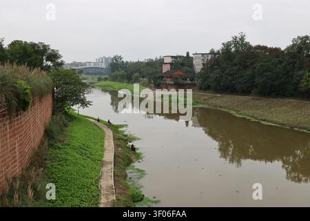 Homme assis sur la rive de la rivière pêchant à Leshan, province du Sichuan en Chine Banque D'Images