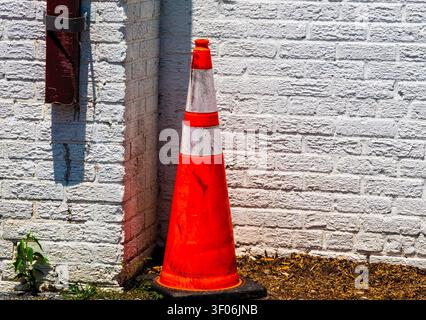 Un cône de circulation de visibilité de Gigh contre un mur blanc Banque D'Images