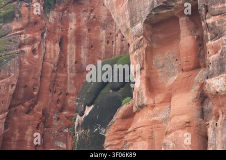 Statue de dieu taillée dans la pierre et Bouddha géant de Leshan assis avec sa main posée sur son genou, province du Sichuan en Chine Banque D'Images