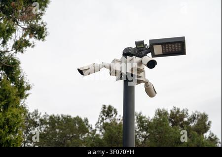 Caméra de sécurité extérieure montée sur un poteau près des arbres. Capture l'environnement à des fins de sécurité et de surveillance dans un environnement tropical. Améliore s Banque D'Images