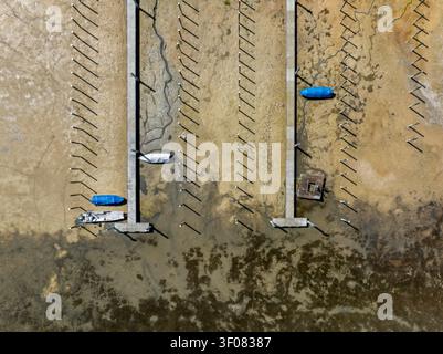Vue aérienne de bateaux bloqués sur le lit asséché du lac de Constance dans une marina de Thurgau, Suisse. Banque D'Images