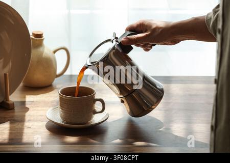 Verser le café du pot de moka dans la tasse en céramique Banque D'Images