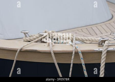 Corde sur un bateau attachée à des taquets, à bord d’un bateau en bois, avec corde, taquets, avec bois, texture métallique, vu d’une perspective de près du pont du bateau Banque D'Images