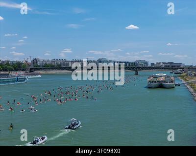 Des centaines de pagayeurs SUP glissent le long du Danube devant les monuments emblématiques de Budapest, dont le Parlement, le château de Buda et le pont des chaînes. Banque D'Images