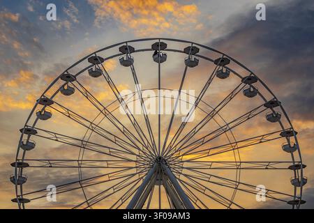 Une grande grande roue contre un ciel magnifique au coucher du soleil Banque D'Images