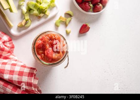 Confiture maison de fraises et raisin de Corinthe dans un pot en verre avec des fraises fraîches et du raisin de Corinthe sur une table de cuisine rustique. Vue de dessus. Banque D'Images