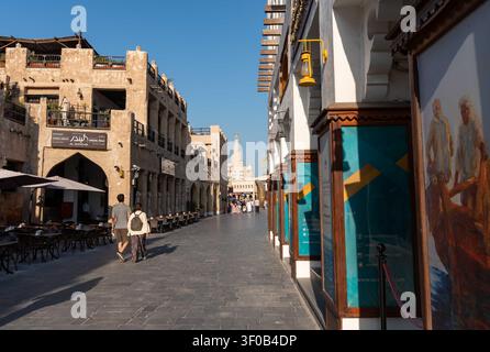 DOHA, QATAR - 14 FÉVRIER 2026 : Vue large d'un couple de touristes marchant le long du chemin pavé de pierre du Souq Waqif à Doha, Qatar. Banque D'Images