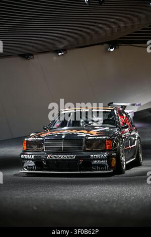 Ville, Pays – 7 juillet 2026 : Voiture de tourisme Mercedes AMG noire avec livrée de sponsor exposée dans un salon automobile intérieur Banque D'Images