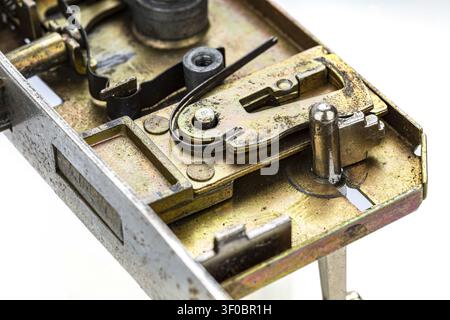 Photographie macro montrant les rouages intérieurs complexes d'un mécanisme de serrure vintage en laiton avec des composants métalliques détaillés, des ressorts, des leviers, des boulons et des goupilles Banque D'Images