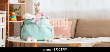 Essentiels pour bébé emballés dans un sac à couches sur la table dans le salon Banque D'Images