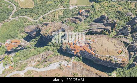 Plan horizontal par drone vu du dessus du célèbre monastère de la Sainte Trinité construit au sommet d'un pilier de roche de grès massif à Météores, en Grèce, par un temps ensoleillé Banque D'Images
