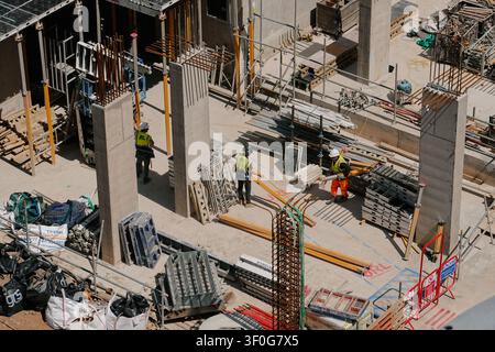 Vue en hauteur sur des ouvriers du bâtiment portant des gilets de sécurité sur un chantier au centre-ville de Birmingham, Royaume-Uni Banque D'Images