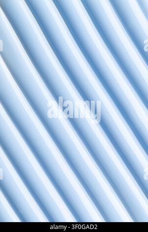 Texture de conception minimaliste d'une surface pastel bleue avec des rayures ondulées rythmiques. Fond abstrait monochromatique présentant un motif linéaire propre, métallique Banque D'Images