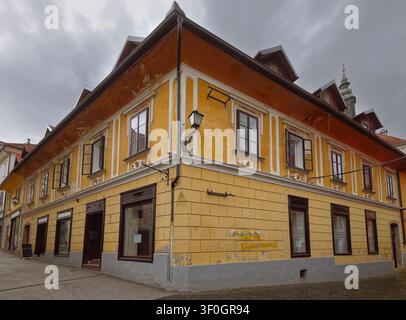 142 Maison d'angle ornée de têtes humaines dépassant de médaillons rhombiques sous les fenêtres, Mestni trg et Blazeva ulica, Skofja Loka-Slovénie Banque D'Images