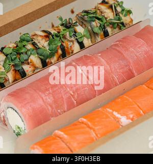 Une vue rapprochée d'une assiette remplie d'une variété de rolls de sushi et de nigiri, mettant en valeur les couleurs vives et les détails complexes de la cuisine japonaise Banque D'Images
