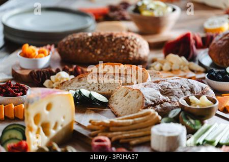 Planche de charcuterie rustique avec pain au levain et fromages variés Banque D'Images