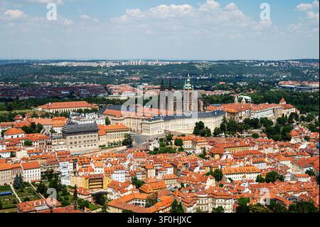 République tchèque, Prague - 25 juin 2026 : Vue montrant les toits de Prague avec des bâtiments historiques et des collines vertes en arrière-plan Banque D'Images