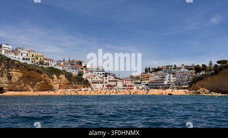Scène de plage dans une ville côtière avec des gens profitant du soleil et de l'eau par une journée claire, Portugal Banque D'Images
