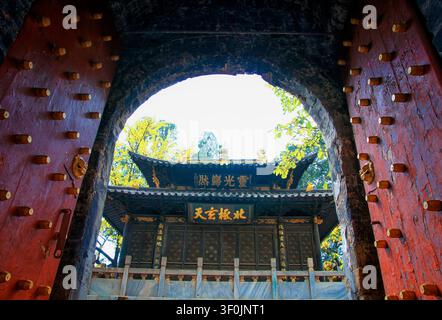 Porte de temple chinois traditionnel avec des portes rouges ornées et des détails dorés sur le toit Banque D'Images