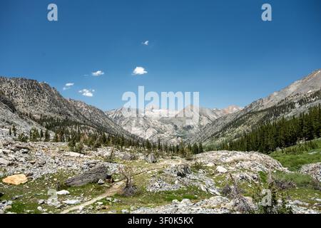 Quelques nuages duveteux dans le ciel bleu au-dessus des dômes du château du parc national de Kings Canyon Banque D'Images