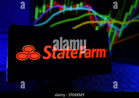 Logo de State Farm Insurance and Financial Services Company sur smartphone avec graphique de performance du marché boursier Banque D'Images