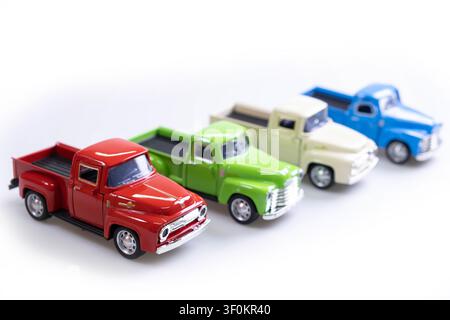 Uttaradit, Thaïlande - 29 juillet 2019 : Quatre modèles de pick-up vintage en rouge, vert, crème et bleu exposés en diagonale sur fond blanc Banque D'Images