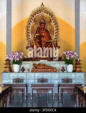 Statue de Guan Yin tenant un enfant et un Bouddha allongé à l'autel de la pagode Linh Ung à Da Nang, Vietnam Banque D'Images