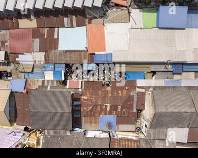 Vue aérienne du marché ferroviaire de Maeklong avec des toits métalliques colorés, des étals de marché bondés et des voies ferrées étroites à Mae Klong, Samut Songkhram, T Banque D'Images