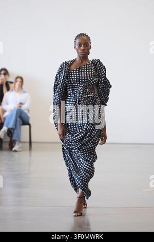 Berlin, Allemagne, 5 juillet 2026. Un mannequin défile pour Fruche dans une robe à carreaux noir et blanc nouée lors de la Berlin Fashion Week SS27. Banque D'Images