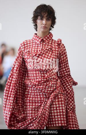 Berlin, Allemagne, 5 juillet 2026. Un mannequin défile pour Fruche dans une robe chemise rouge à carreaux vichy lors de la Berlin Fashion Week SS27. Banque D'Images