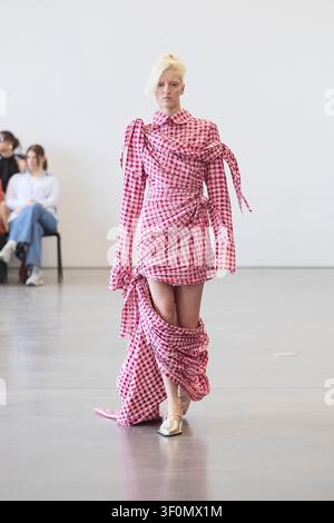 Berlin, Allemagne, 5 juillet 2026. Un mannequin défile pour Fruche dans une robe portefeuille en vichy rose lors du défilé de la Berlin Fashion Week SS27. Banque D'Images