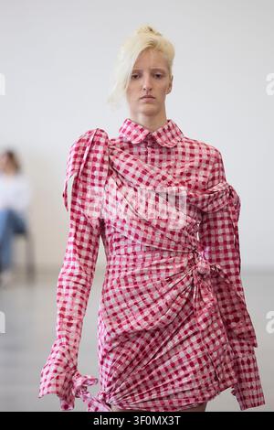 Berlin, Allemagne, 5 juillet 2026. Un mannequin défile pour Fruche dans une robe portefeuille en vichy rose lors du défilé de la Berlin Fashion Week SS27. Banque D'Images