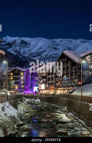 Village de station de ski alpin enneigé de Verbier, canton du Valais, Suisse, photographié de nuit avec l'hôtel National NZ brillamment éclairé en premier plan Banque D'Images