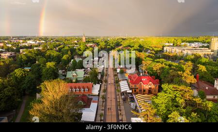 Vue aérienne de Palanga avec un double arc-en-ciel sur la ville après une tempête d'été au coucher de soleil doré, Lituanie Banque D'Images
