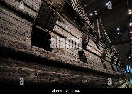 Stockholm, Suède-28 novembre 2025 : gros plan des embrasures de canon et de la texture de la coque en bois sur le côté de l'épave du Vasa dans le musée. Banque D'Images