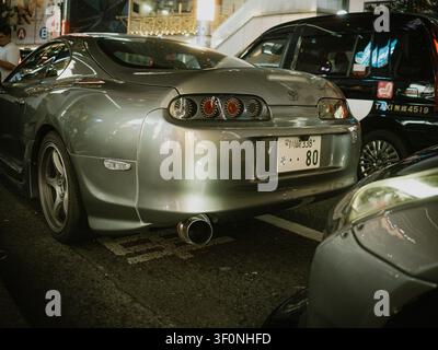 Vue arrière d'une voiture de sport Toyota Supra argentée garée dans une rue la nuit à Dogenzaka, Shibuya, Tokyo, Japon Banque D'Images