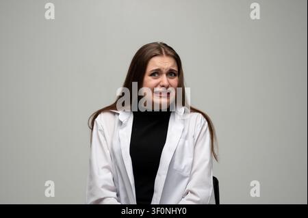 Femme exprimant du dégoût, ressentant de l'aversion ou une répulsion, grimçant avec une émotion négative et du mécontentement Banque D'Images