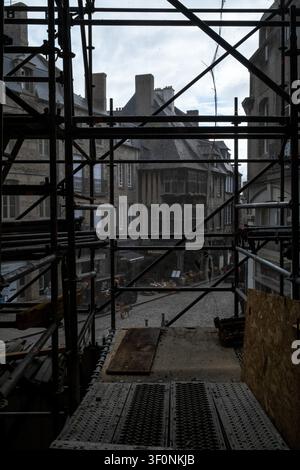 Vue intérieure depuis le site de conservation et de reconstruction de la Maison de la Mere Pourcel à travers un lourd échafaudage vers la rue médiévale et la construction en bois Banque D'Images