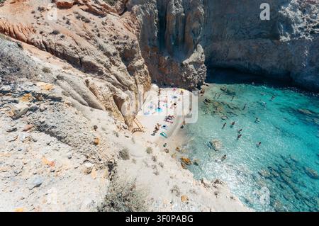 Les vacanciers nagent et se détendent sur les rives sablonneuses de Tsigrado Beach à Milos, Grèce Banque D'Images