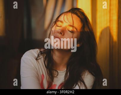Portrait d'une jeune femme d'une beauté naturelle dans la lumière du coucher de soleil Banque D'Images