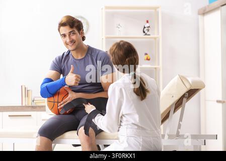 Beau joueur de basket-ball féminin en visite médecin traumatologist Banque D'Images