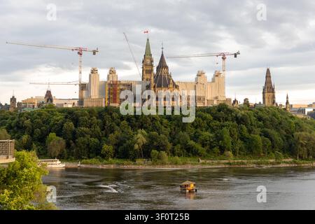 Vue de la colline du Parlement depuis la rivière avec un petit bateau croisant sur la rivière des Outaouais au Canada Banque D'Images