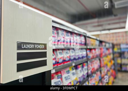 Informations de signalisation de la catégorie de produits détergent en poudre pour la lessive domestique sur l’allée d’un supermarché comme guide pour les clients dans leur mission d’achat. Sho Banque D'Images